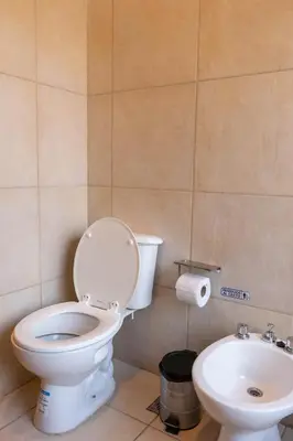 a bathroom with a toilet and a sink at Cabañas Miraluna in Villa General Belgrano