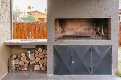 a garage with a sink and a pile of logs at Cabañas Miraluna in Villa General Belgrano