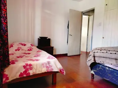 a bedroom with a bed and a dresser and a door at Guemes270 in San Roque