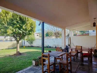 a patio with a table and chairs and a tree at Guemes270 in San Roque