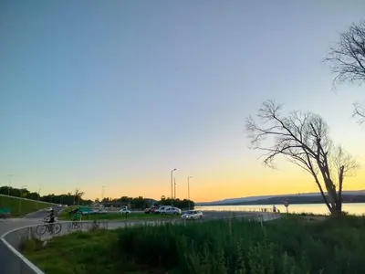 a person riding a bike on a road next to a lake at Guemes270 in San Roque