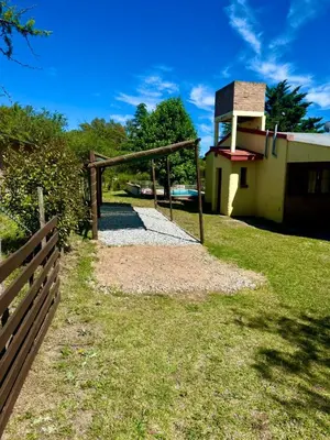 a wooden fence next to a building with a tower at Alma de Lago in Villa Rumipal