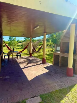 a pavilion with a hammock and a table and benches at Alma de Lago in Villa Rumipal