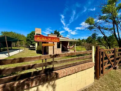 a fence in front of a building with a sign at Alma de Lago in Villa Rumipal