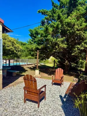 two wooden chairs sitting next to a tree at Alma de Lago in Villa Rumipal