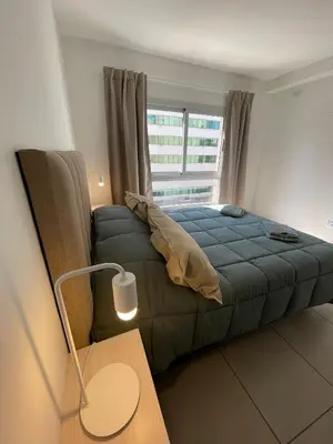 a bedroom with a large bed and a window at CATEGORIA departamento a dos cuadras del patio olmos 1 dormitorio asador pileta y cochera in Cordoba
