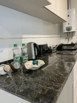 a kitchen counter with two bottles of water on it at CATEGORIA departamento a dos cuadras del patio olmos 1 dormitorio asador pileta y cochera in Cordoba