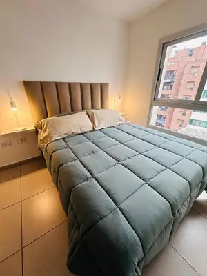 a bedroom with a large bed with a large window at CATEGORIA departamento a dos cuadras del patio olmos 1 dormitorio asador pileta y cochera in Cordoba