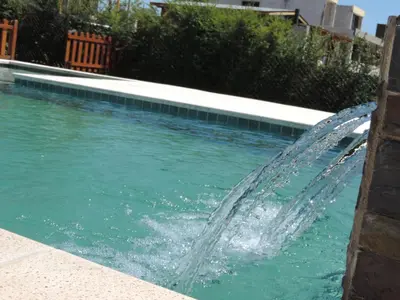 a water fountain in a swimming pool at Cabañas Aires de Montaña in La Estancia