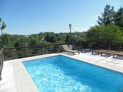 a swimming pool with two benches next to at Cabañas los amigos Pino in Potrero de Garay