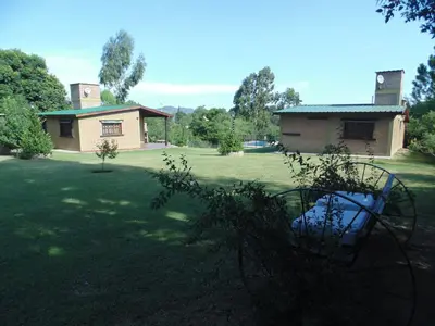 a large yard with a house and a building at Cabañas los amigos Pino in Potrero de Garay