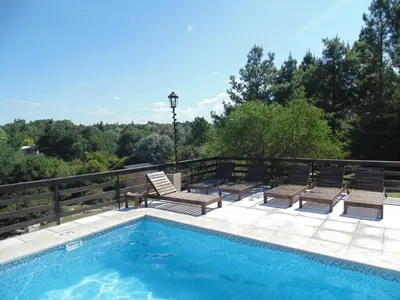 a swimming pool with two chairs and a table at Cabañas los amigos Pino in Potrero de Garay