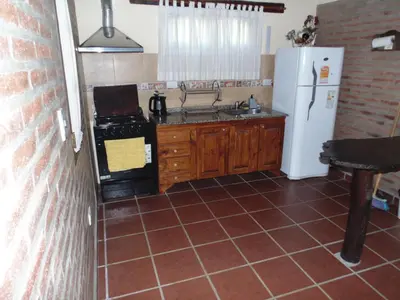 a kitchen with a white refrigerator and a stove at Cabañas los amigos Pino in Potrero de Garay