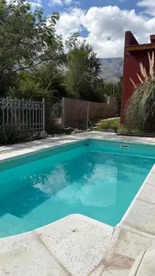a swimming pool with blue water in a yard at Luz del Rincón in Merlo