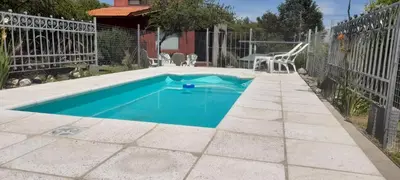 a swimming pool in a yard with a fence at Luz del Rincón in Merlo