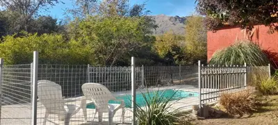 a fence with chairs and a swimming pool at Luz del Rincón in Merlo