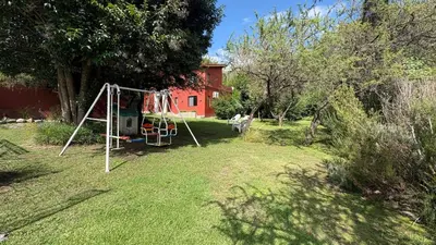 a yard with a swing set in the grass at Luz del Rincón in Merlo