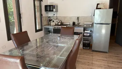 a kitchen with a table and chairs and a refrigerator at Luz del Rincón in Merlo