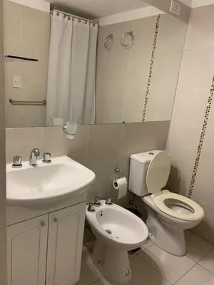 a bathroom with a white toilet and a sink at Hermoso departamento amoblado ubicado en pleno Nueva Córdoba in Cordoba