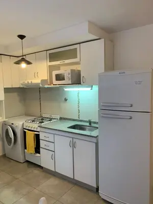 a kitchen with a white refrigerator and a microwave at Hermoso departamento amoblado ubicado en pleno Nueva Córdoba in Cordoba