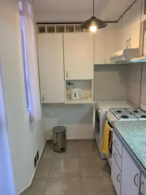 a kitchen with white cabinets and a stove top oven at Hermoso departamento amoblado ubicado en pleno Nueva Córdoba in Cordoba