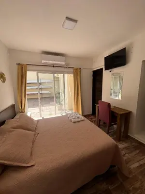 a bedroom with a large bed and a window at Complejo Roccatini in Villa Carlos Paz