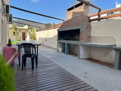 a patio with a table and a brick oven at Complejo Roccatini in Villa Carlos Paz