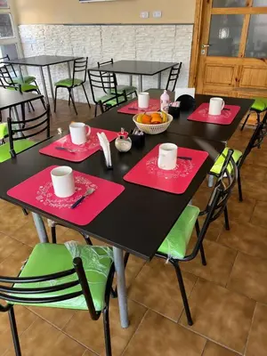 a black table with red napkins and green chairs at Complejo Roccatini in Villa Carlos Paz