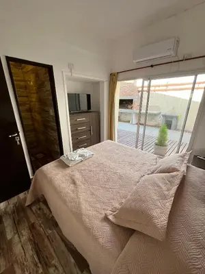 a bedroom with a large bed with a large window at Complejo Roccatini in Villa Carlos Paz