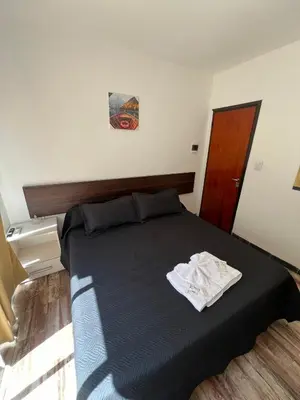 a bedroom with a bed with a black comforter at Complejo Roccatini in Villa Carlos Paz
