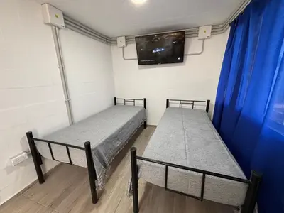 two beds in a room with a tv on the wall at Amanecer Serrano Carlos Paz in Villa Carlos Paz