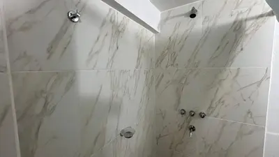 a bathroom with a shower with marble tiles at Amanecer Serrano Carlos Paz in Villa Carlos Paz