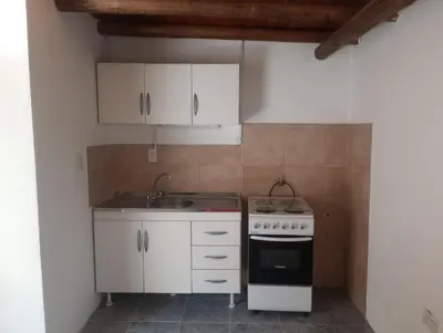 a kitchen with white cabinets and a sink and a stove at Magnolias in Villa General Belgrano