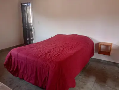 a bed with a red bedspread in a room at Magnolias in Villa General Belgrano