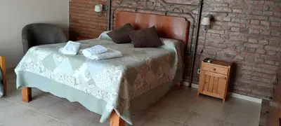 a bedroom with a bed and a brick wall at Alma Dulce in Almafuerte