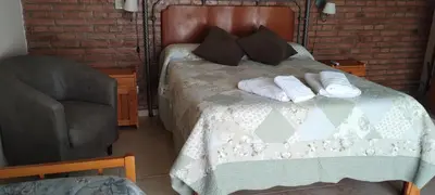 a bedroom with a bed with two pillows and a chair at Alma Dulce in Almafuerte