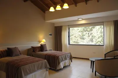 a hotel room with two beds and a window at Lom Suites in Merlo