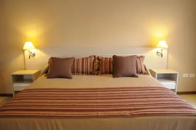 a bedroom with a large bed with two night stands at Lom Suites in Merlo