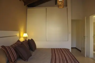 a bedroom with a bed with a large headboard at Lom Suites in Merlo