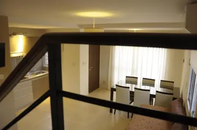 a kitchen and dining room with a table and chairs at Lom Suites in Merlo