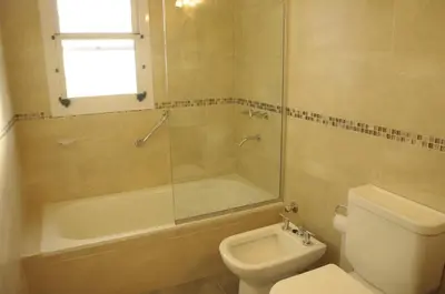 a bathroom with a toilet and a shower and a sink at Lom Suites in Merlo