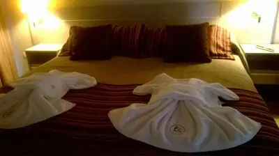 two towels on a bed in a hotel room at Lom Suites in Merlo