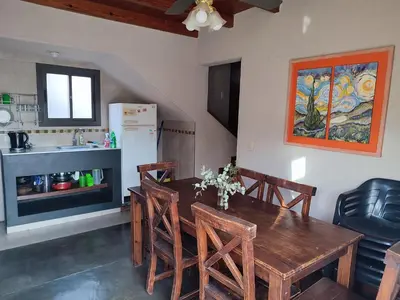 a kitchen with a wooden dining room table with chairs at Cabañas De La Vertiente in La Bolsa