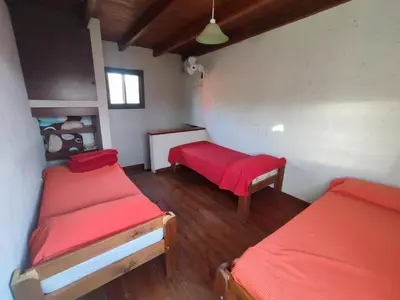 a room with two beds and a bench in it at Cabañas De La Vertiente in La Bolsa