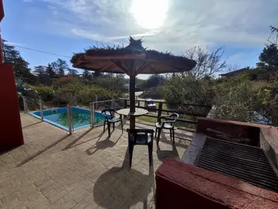 a patio with an umbrella and a table and chairs at Cabañas De La Vertiente in La Bolsa