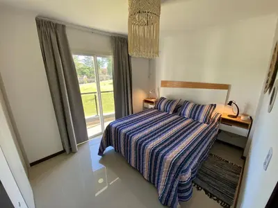 a bedroom with a bed with a striped blanket and a window at Venetto Village in Villa Parque Siquiman
