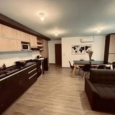 a kitchen and living room with a table and a couch at Depto Villa Carlos Paz in Villa Carlos Paz