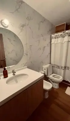 a bathroom with a sink and a toilet and a mirror at Depto Villa Carlos Paz in Villa Carlos Paz