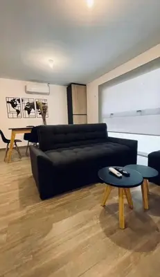 a living room with a black couch and a table at Depto Villa Carlos Paz in Villa Carlos Paz