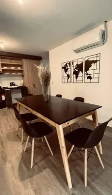 a dining room table with chairs and a black table at Depto Villa Carlos Paz in Villa Carlos Paz